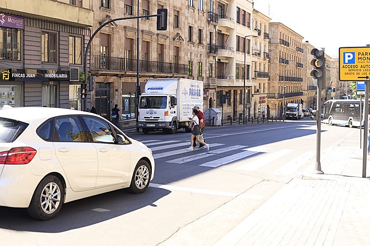 Peatón cruzando en un semáforo verde en la Gran Vía.