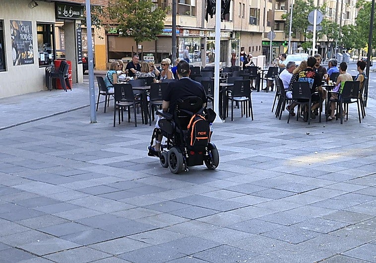 Una persona con movilidad reducida se acerca a una terraza.