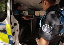 Dos agentes de la Policía Local de Salamanca, en uno de los vehículos policiales.