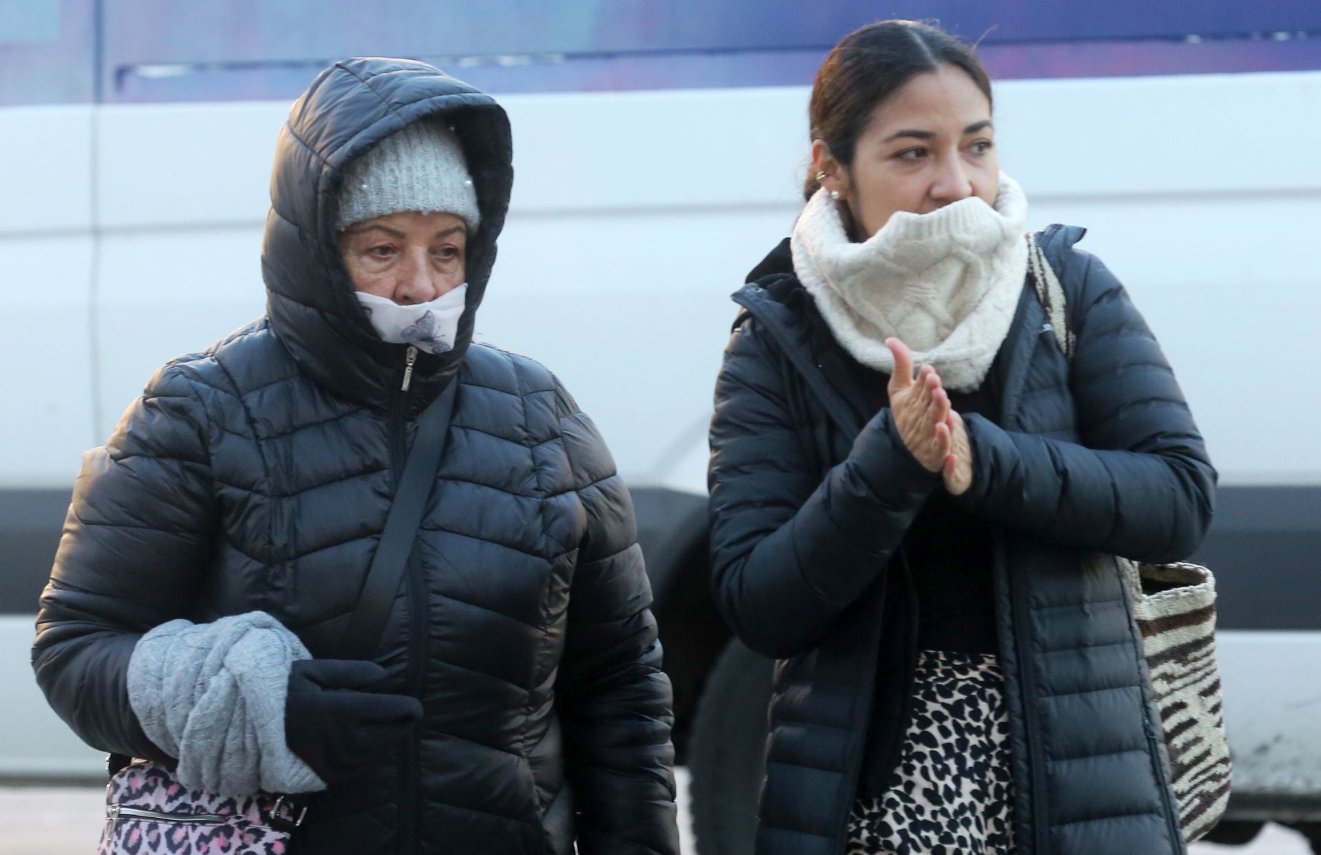 Dos mujeres tratan de protegerse del frío.