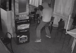 Uno de los autores trata de romper la máquina tragaperras en un bar de San José.