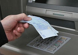 Una persona retira dinero de un cajero en una imagen de archivo.