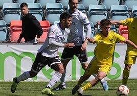 Martín Galván lucha por un balón ante un rival del Langreo.