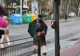 Una mujer cruza la calle con un paraguas en Salamanca