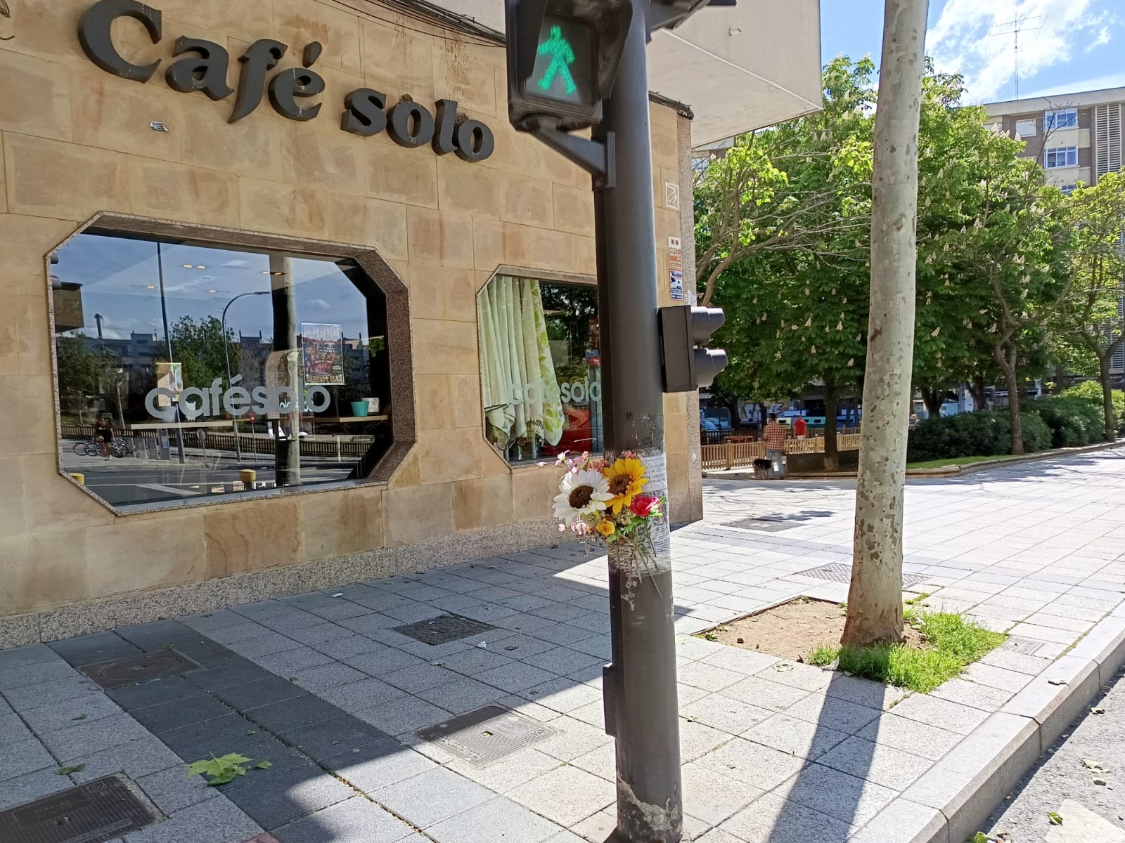 Semáforo en el lugar del atropello con flores en recuerdo de la mujer fallecida.