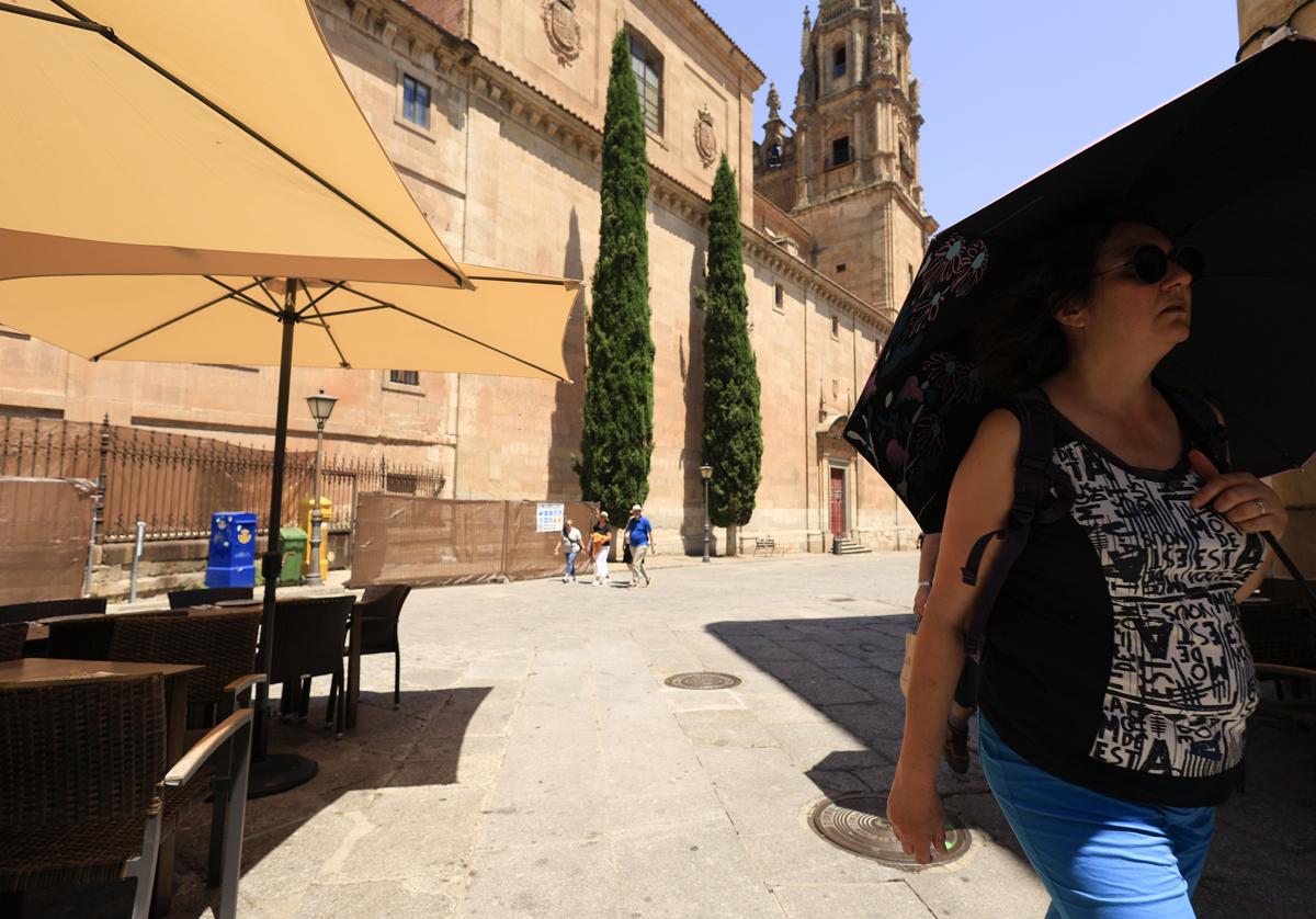 Turista se protege del sol con un paraguas