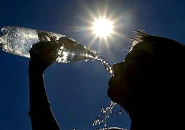 Una persona bebe agua en un día de mucho calor en una imagen de archivo.