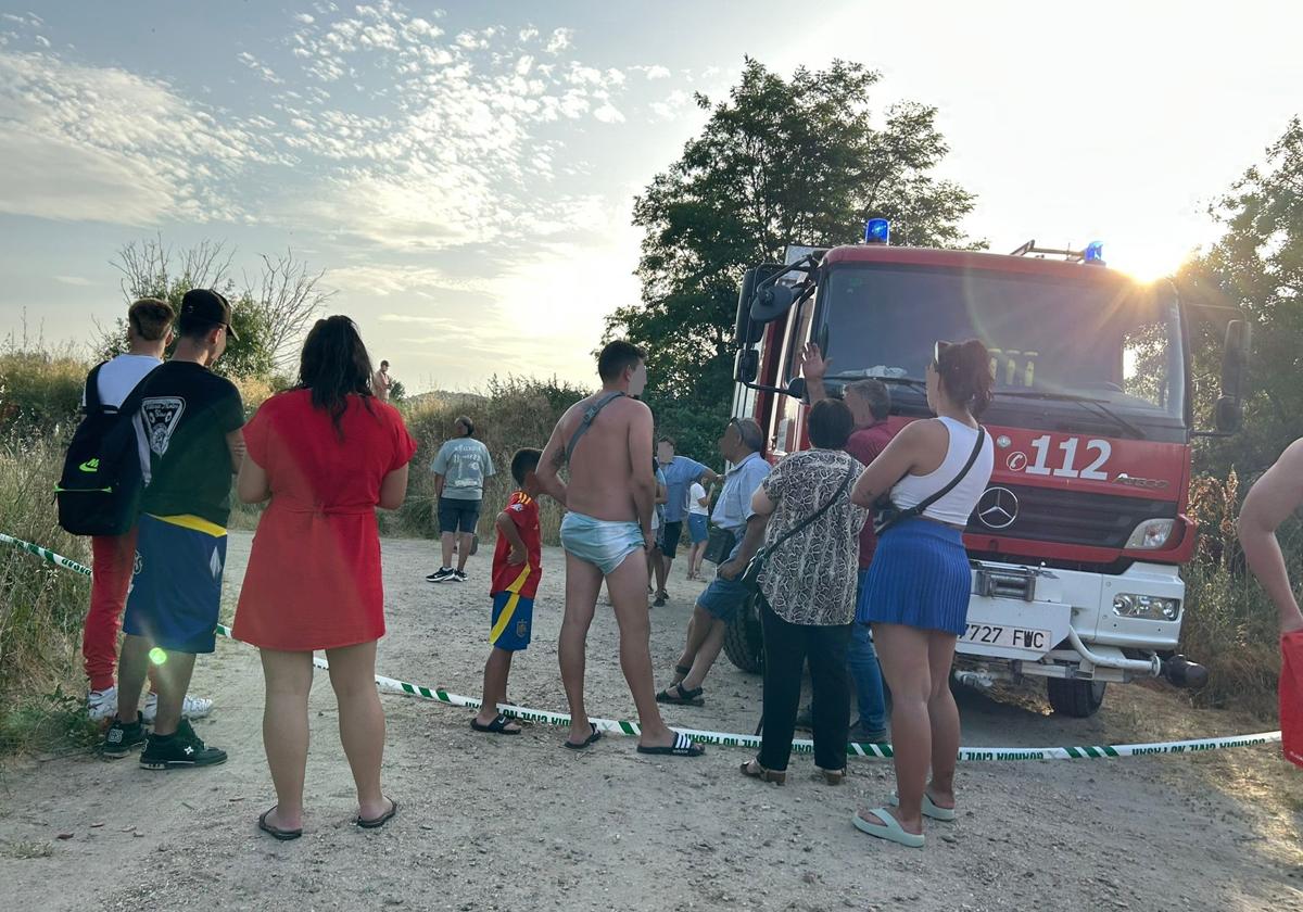 Bañistas en la zona donde se busca al joven desaparecido en Alba de Tormes junto a un campeón de bomberos de la Diputación de Salamanca.