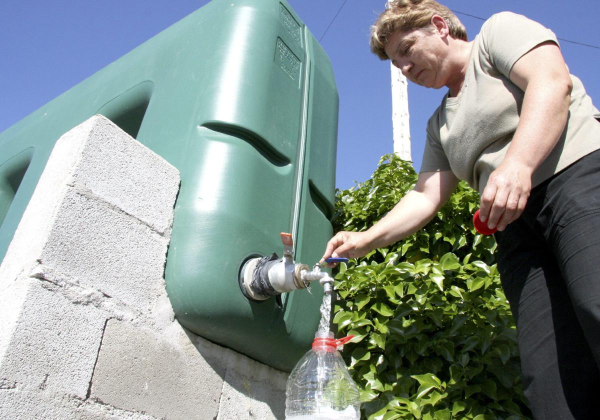 Una vecina de Buenamadre coge agua de un depósito instalado