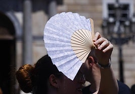 Una turista utiliza una sombrilla para protegerse del sol