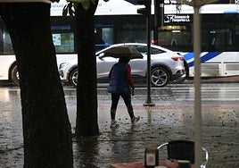 Imagen de archivo de una mujer en plena tormenta en Salamanca.
