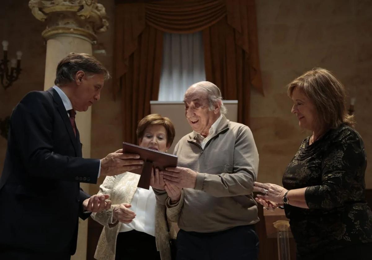 Carlos García Carbayo hace entrega de una placa a un matrimonio por sus bodas de oro.