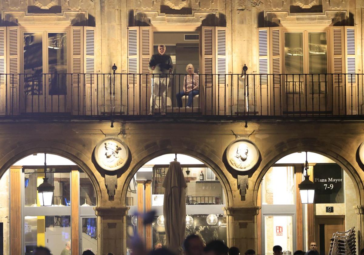 Unas personas siguen desde un balón de la Plaza Mayor de Salamanca una actuación.
