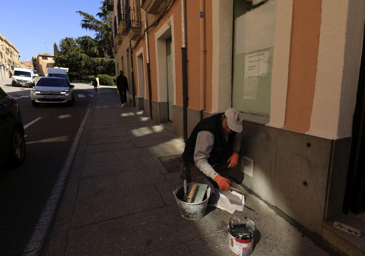 Trabajador pintando una fachada en la calle San Pablo.