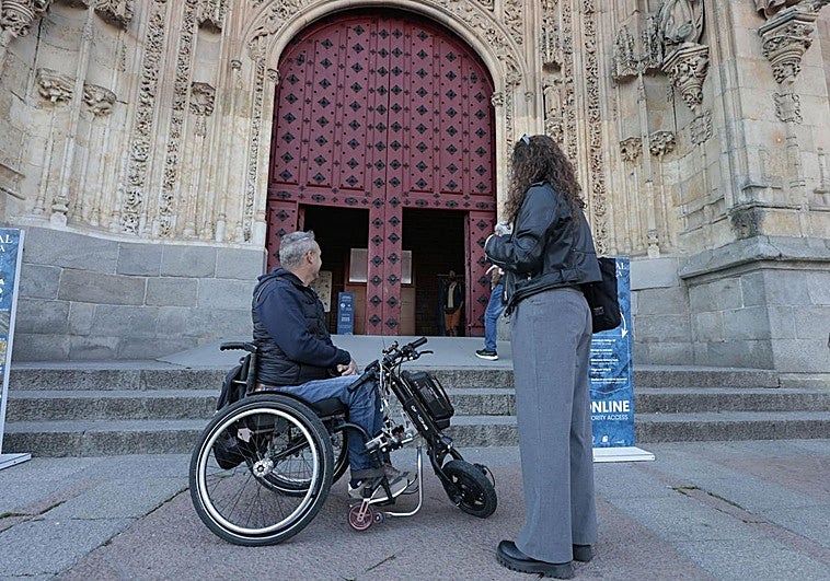 Imagen de archivo de una persona en silla de ruedas en la puerta de la Catedral de Salamanca.
