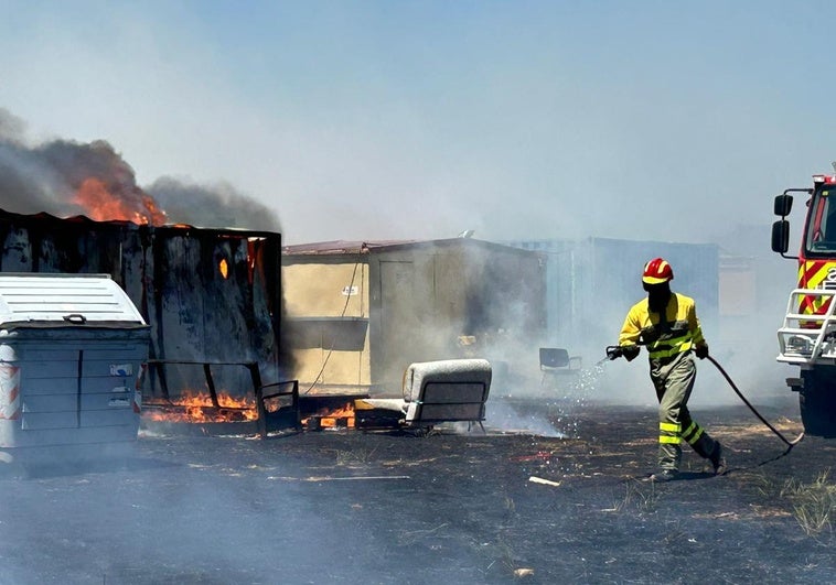 Los bomberos tratan de apagar las llamas en las casetas de Santa Marta.