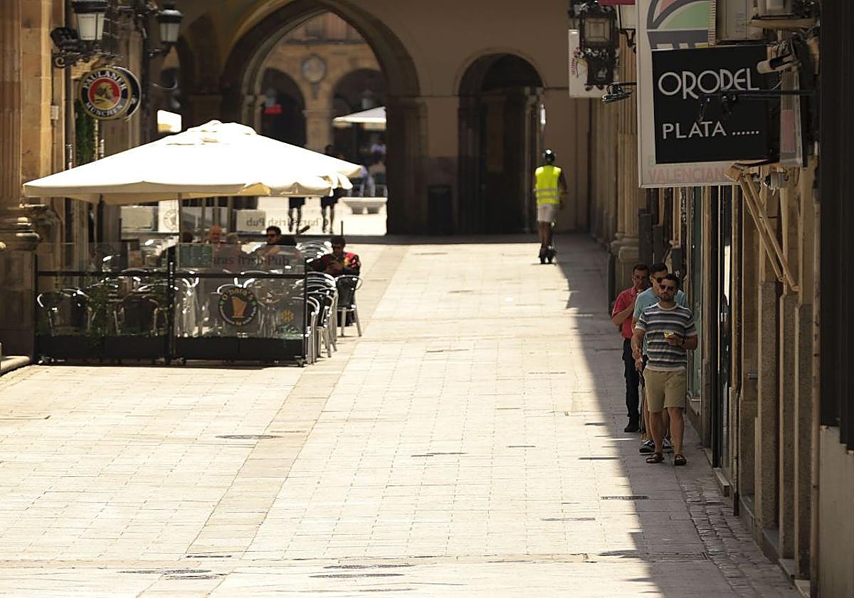Paseanes se resguardan del calor en la sombra.