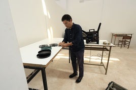 Alberto Cabrera junto a un proyector de 16 mm y varias bobinas de películas.