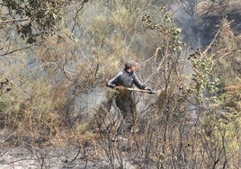 Un hombre ayuda a sofocar las llamas en el incendio de La Alberca.
