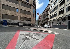 Una de las señales de peligro escolar de grandes dimensiones pintada en la calzada.