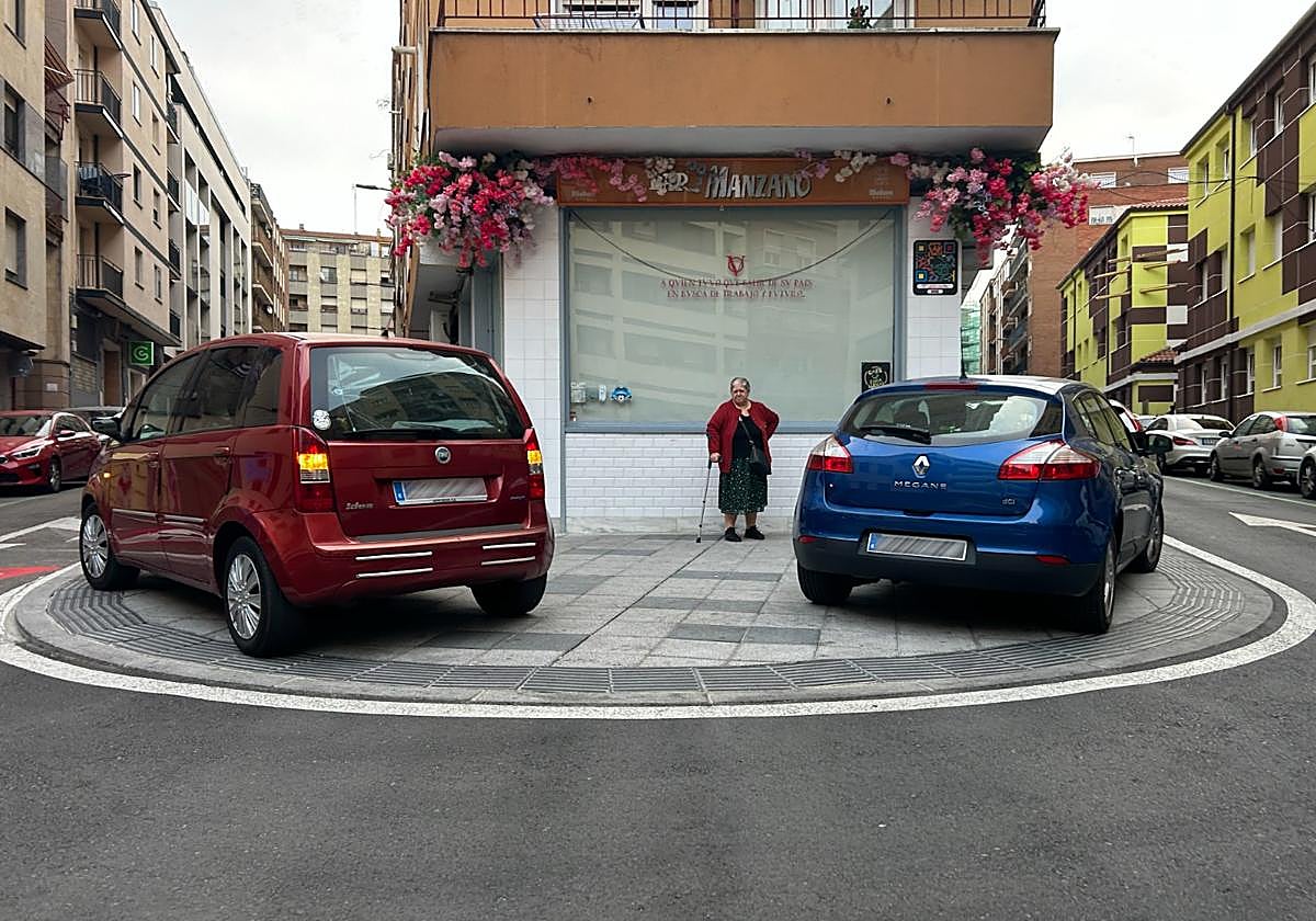 Dos coches aparcados sobre la acera al lado de un colegio este martes por la mañana.