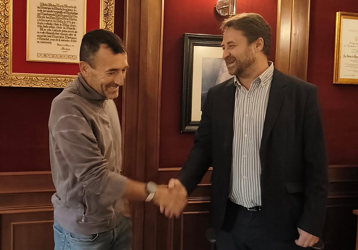 Antonio Cámara, alcalde de Béjar, y Miguel Heras, estrechan sus manos tras el acuerdo para el regreso del deportista bejarano al consistorio textil.
