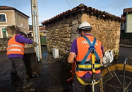 Operarios de la empresa de telecomunicaciones instalan la fibra óptica.