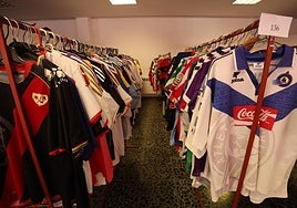 Decenas de camisetas de fútbol colgadas en perchas.