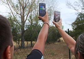 Dos personas sujetan sus móviles en el campo en una imagen de archivo.