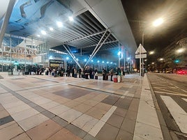 Cola de pasajeros esperando un taxi en la estación de trenes.