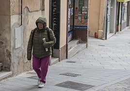 Una señora con capucha en una fría mañana dando un paseo.