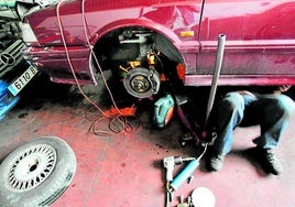 Ein Kfz-Mechaniker bei der Reparatur an einem Auto.