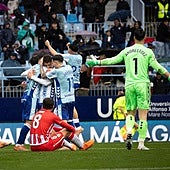 Die Spieler von Málaga umarmen Dani Lorenzo nach einem Weltklassetor.