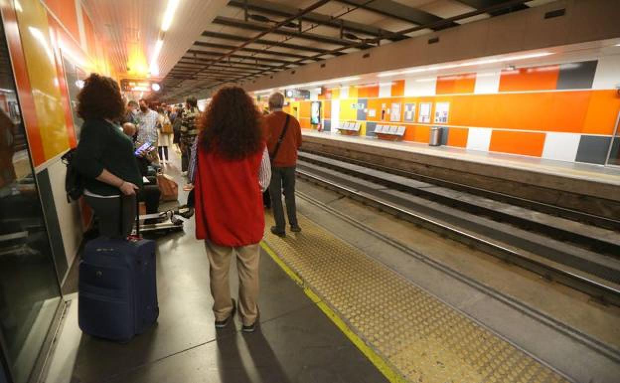 Passengers wait on a station platform for a Cercanía train. 