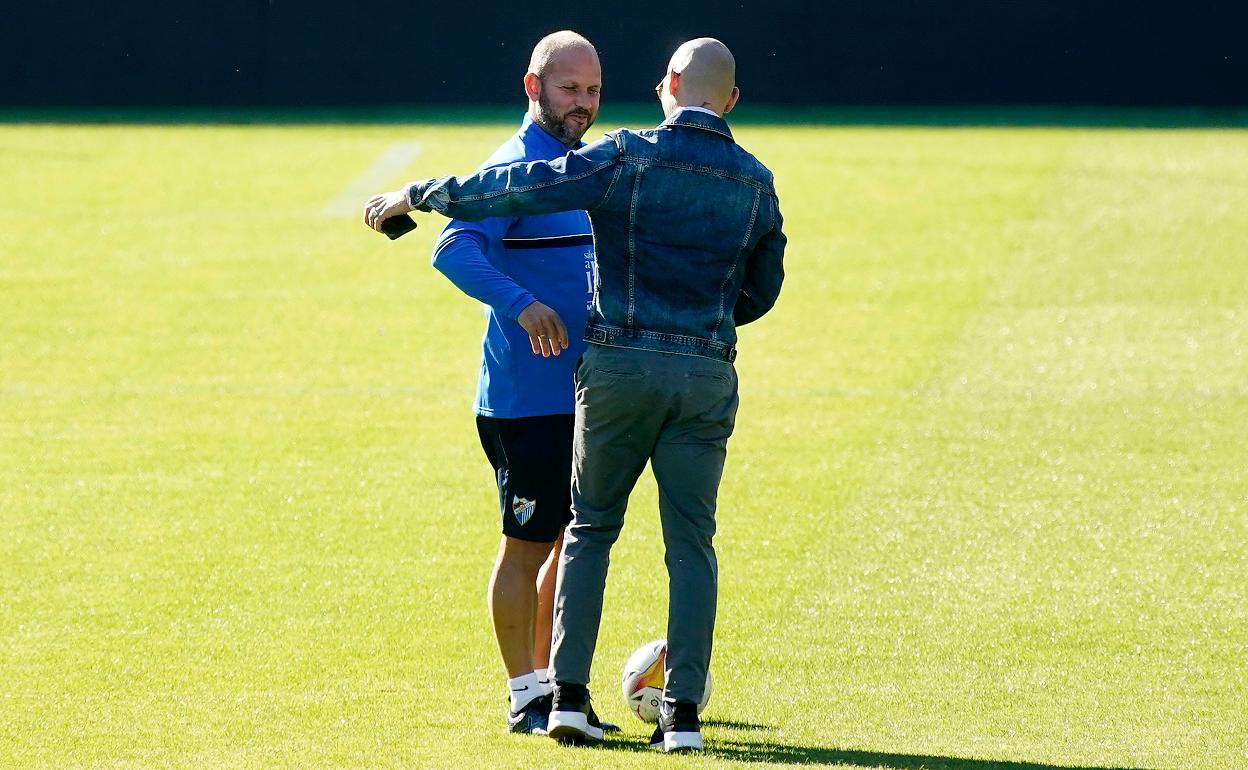 Head coach José Alberto greets Malaga's sporting director, Manolo Gaspar. 