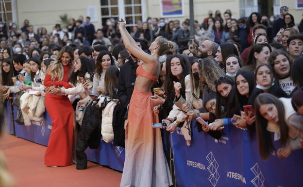 An actress takes a selfie with fans. 