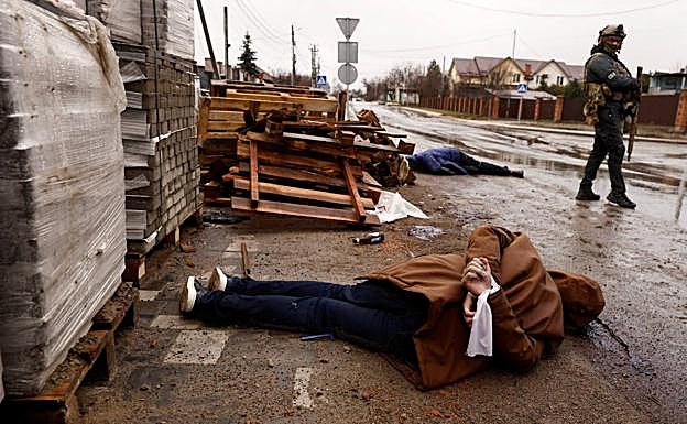The body of a man with his hands tied behind his back lies on the ground in a street in Bucha, a town near kyiv, recently recaptured by Ukrainian forces.