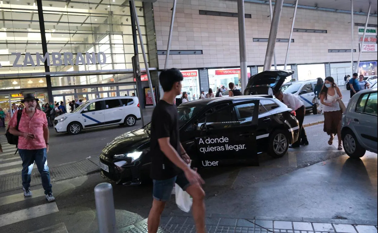 An Uber cab picks up passengers a Malaga train station.