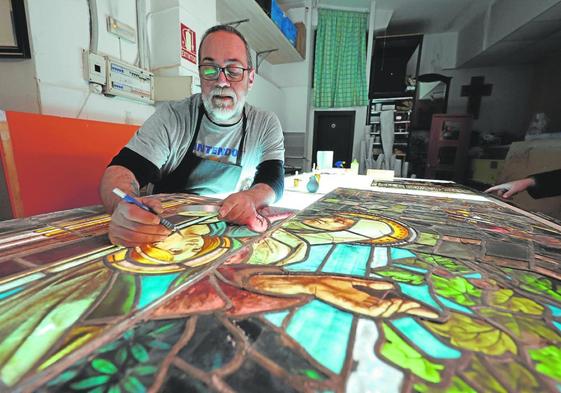 José Luis Camacho analyses one of the pieces on an illuminated table.