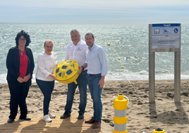 Ana Mula (2nd left) inspects one of the acoustic beacons on Las Gaviotas beach.