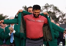 Rahm is given the iconic green jacket reserved for winners at Augusta.