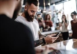 A younger user makes a Bizum payment in a shop.