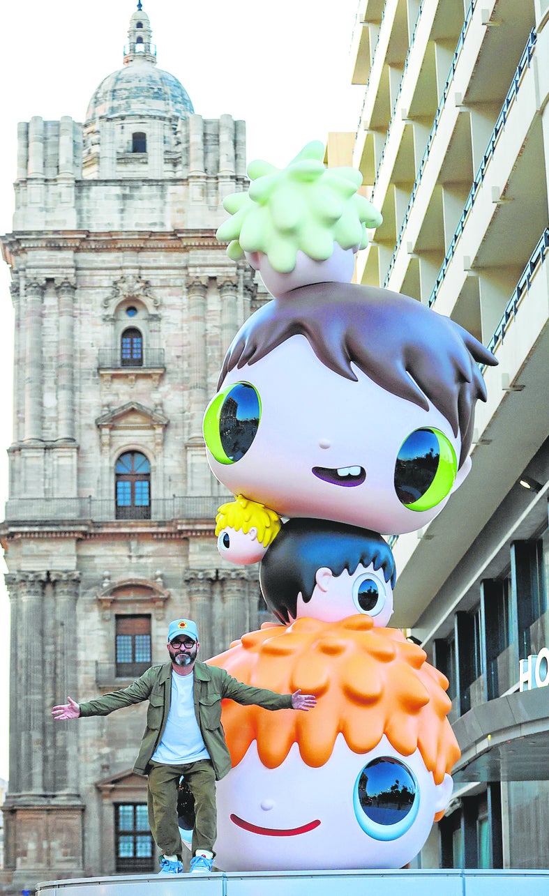 Javier Calleja, with his sculpture at the entrance to Calle Molina Lario in Malaga.