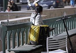 Glovo courier waiting for orders in front of Mcdonalds in Plaza de la Marina.