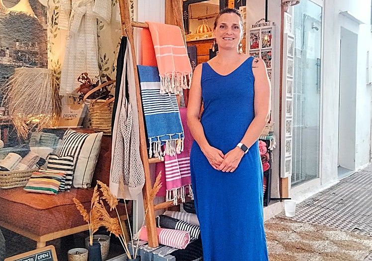 Imagen principal - Sarah at the door of the shop. 