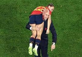 Luis Rubiales carries Athenea del Castillo over his shoulder.