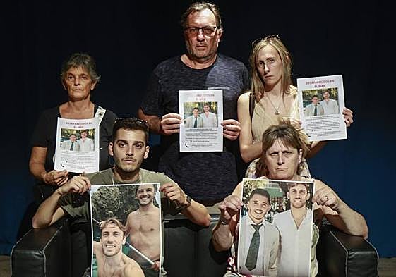 Relatives of Emma and Maxi, with the posters of the two missing young people.