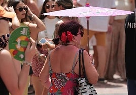 A tourist takes shelter from the sun during the Malaga fair.