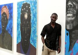 Atanda Quadri Adebayo in front of some of his canvases.
