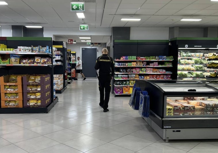 A security guard monitors the aisles inside a supermarket in Malaga city.